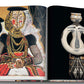 A book open to a page with a colorful illustration of a tribal figure on the left and a photograph of a tribal mask or figurine on the right from The Impossible Collection: Yves Saint-Laurent by Assouline.