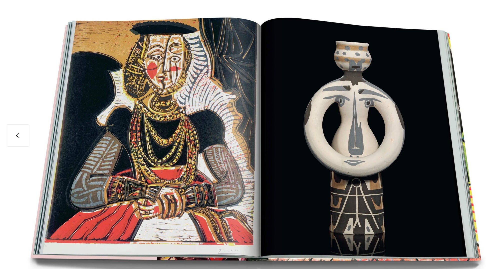 A book open to a page with a colorful illustration of a tribal figure on the left and a photograph of a tribal mask or figurine on the right from The Impossible Collection: Yves Saint-Laurent by Assouline.