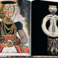 An open book displays a painting of a person intertwined with geometric patterns, set beside a sculpture echoing the sleek elegance of Italian design, reminiscent of the Riva Aquarama's iconic style by Assouline.
