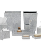 The Pigeon & Poodle Callas Bath Collection features silver speckled bathroom accessories—tissue box, soap dispenser, tray, sanitizer bottle, and wastebasket—all elegantly arranged with a mosaic touch.