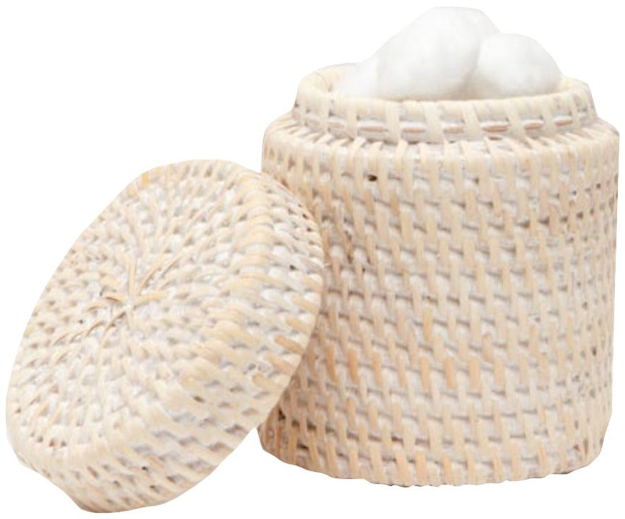 From the Dalton Bath Collection by Pigeon & Poodle, this round woven rattan basket with a detached lid displays detailed craftsmanship and holds white cotton balls.