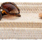 Two rectangular woven trays from the Dalton Bath Collection by Pigeon & Poodle highlight detailed craftsmanship, stacked with tortoiseshell sunglasses and a small brown rock placed on the top tray.