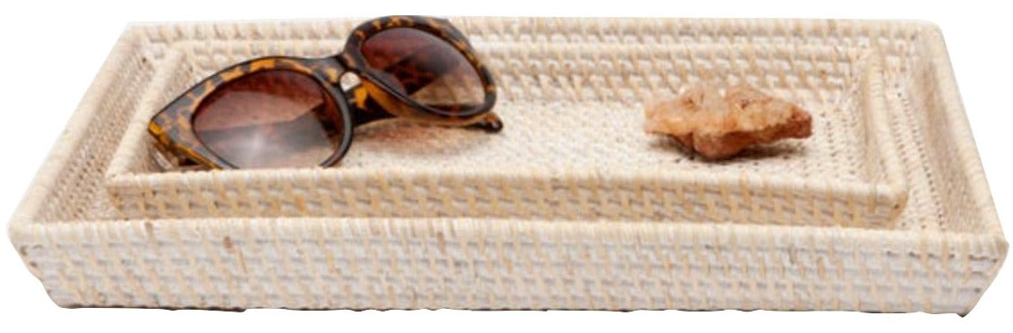Two rectangular woven trays from the Dalton Bath Collection by Pigeon & Poodle highlight detailed craftsmanship, stacked with tortoiseshell sunglasses and a small brown rock placed on the top tray.