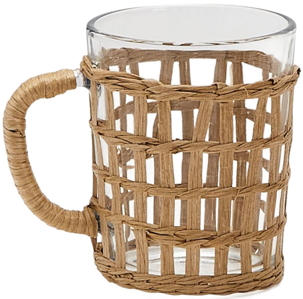 A clear glass mug with a Two's Company Island Chic Hand-Woven Lattice overlay and handle, exhibiting island chic.