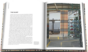 An open Burberry Book by Assouline reveals text about "The Scarf" on the left and shows an image of a loom weaving a classic British-style patterned scarf on the right.
