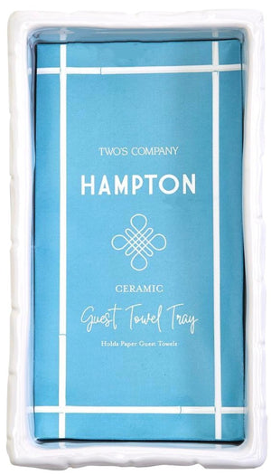 The Hampton Faux Bamboo Fretwork Guest Towel Tray by Two's Company is a white rectangular holder with faux bamboo detailing, perfect for displaying a stack of paper guest towels in elegant Chinoiserie-inspired style.