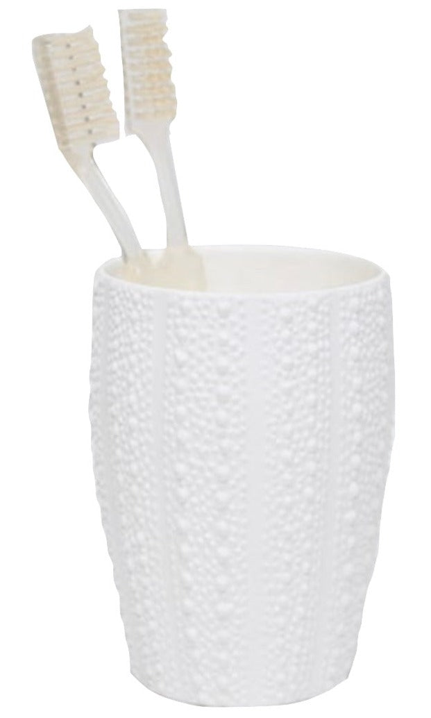 Two beige toothbrushes rest in a white Hilo Bath Collection cup by Pigeon & Poodle, featuring a textured sea urchin-inspired design.