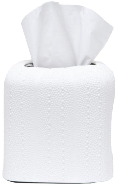 A roll of white toilet paper from the Hilo Bath Collection by Pigeon & Poodle, with a tissue pulled halfway out from the center, rests on a porcelain surface.