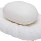 A white soap sits on the Hilo Bath Collection’s textured oval porcelain dish by Pigeon & Poodle, both in shades of white with a subtle sea urchin motif, against a plain background.