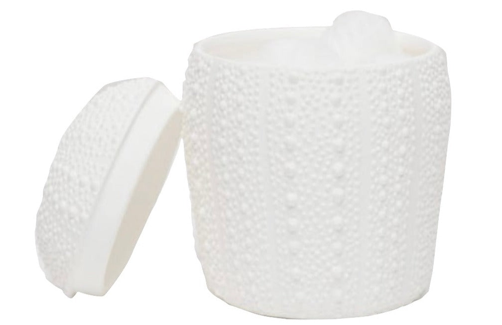 An open white porcelain container from the Hilo Bath Collection by Pigeon & Poodle displays cotton balls inside, featuring a textured sea urchin pattern that reflects coastal elegance.
