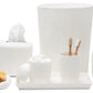 The Pigeon & Poodle Hilo Bath Collection includes a white porcelain set with a subtle sea urchin pattern: trash bin, tissue box, soap dispenser, toothbrush holder (with two brushes), two cups, tray, and bath sponges.