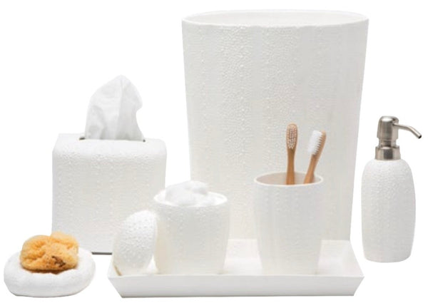 The Pigeon & Poodle Hilo Bath Collection by Pigeon & Poodle is a white porcelain set featuring a wastebasket, tissue box, soap dispenser, toothbrush holder, tray, and sponge. It adds elegance and style to any bathroom.