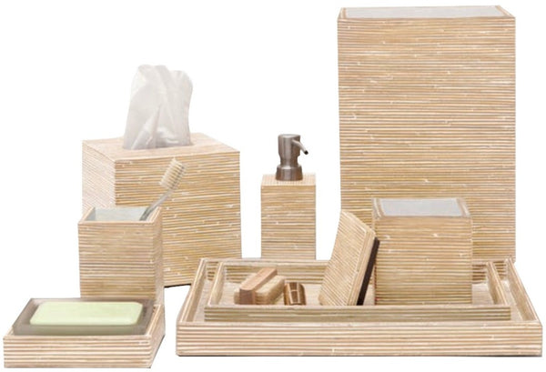 A set of Pigeon & Poodle Kona Collection bathroom accessories including tissue box cover, soap dispenser, toothbrush holder, soap dish, and a tray with compartments, all with a matching rattan wood-like finish.