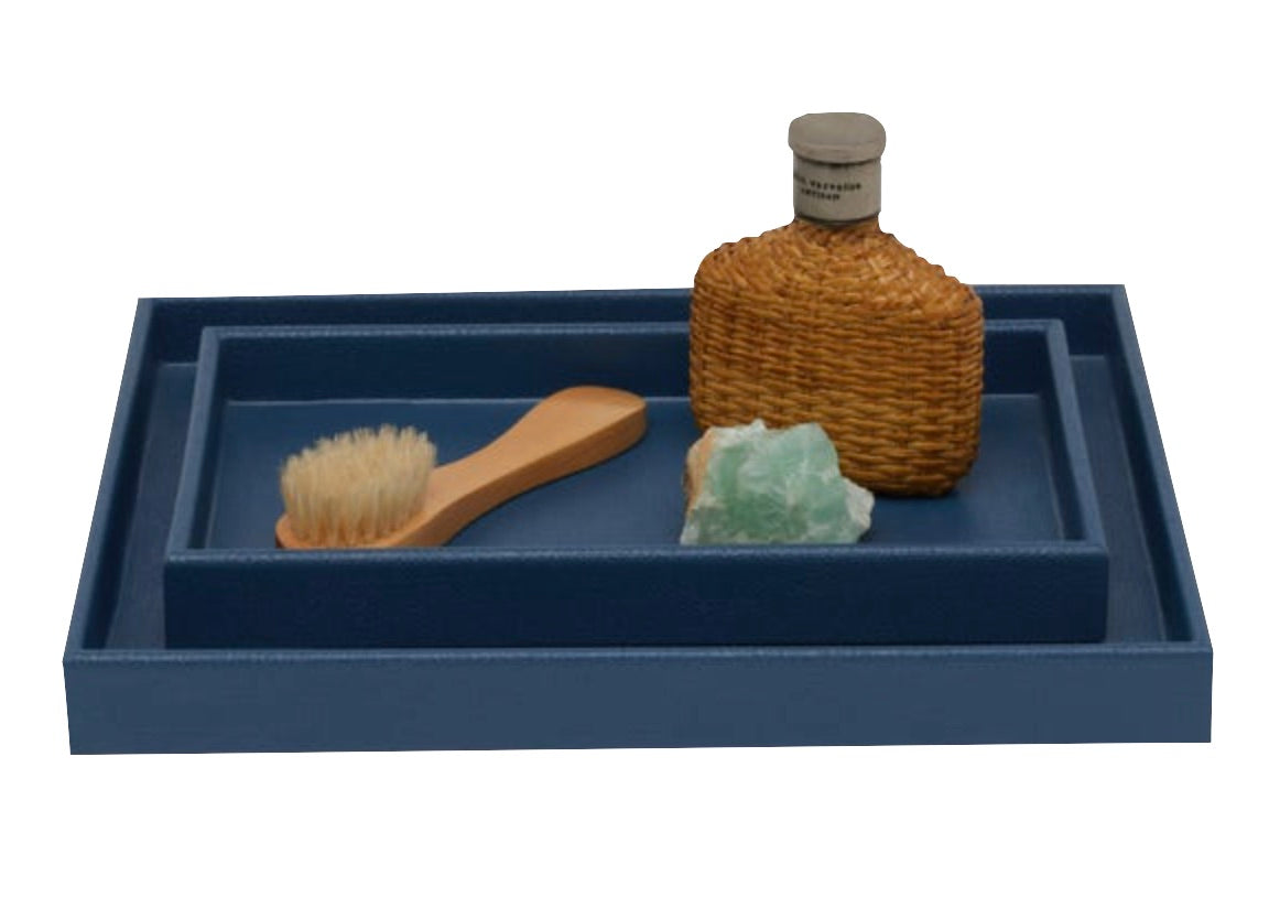A blue tray from Pigeon & Poodle's Dannes Bath Collection in faux waxed Belgian linen holds a wooden brush, green soap bar, and a wicker-wrapped bottle—an elegant bath triple threat.