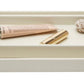 Two rectangular trays from the Dannes Bath Collection by Pigeon & Poodle, in faux waxed Belgian linen, hold a tube, a gold cylinder, and a rattan ball on white—an elegant monochrome display.