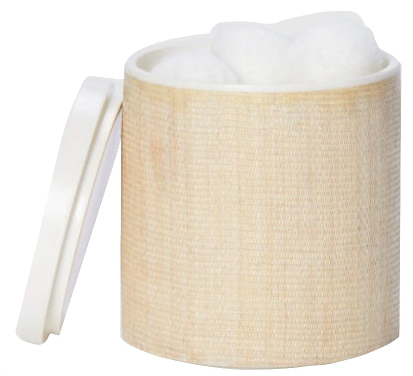 A cylindrical container from the Maranello Bath Collection by Pigeon & Poodle, featuring a textured light tan abaca-resin surface, is filled with white cotton balls and has its white lid placed nearby.