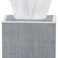 A square gray tissue box from Pigeon & Poodle’s Maranello Bath Collection, made with abaca-resin, displays a single white tissue partially pulled out from the top.