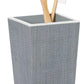 A grey textured cup from the Pigeon & Poodle Maranello Bath Collection holds two wooden-handled toothbrushes with white bristles.