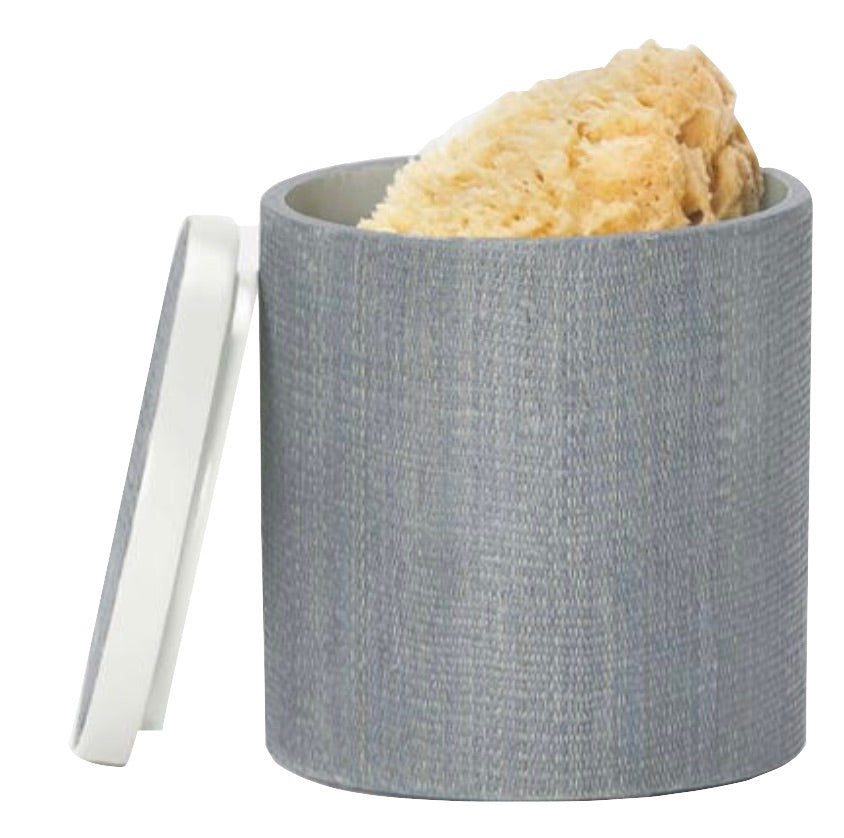 A gray cylindrical container from Pigeon & Poodle's Maranello Bath Collection with a separate white lid, containing a natural sponge inside.