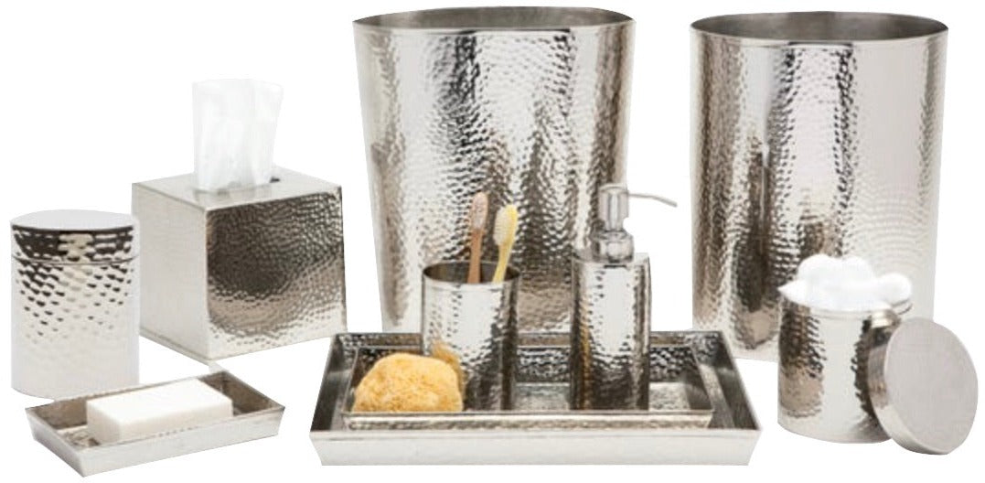 The Verum Bath Collection by Pigeon & Poodle features hand-hammered silver metal accessories, including a waste bin, tray, container, soap dispenser, toothbrush holder, tissue box cover, and cotton jar.