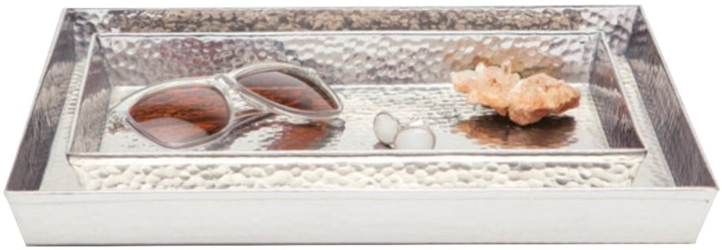 A rectangular hand-hammered metal tray from the Pigeon & Poodle Verum Bath Collection holds a pair of sunglasses, a coral piece, and two small white spheres.