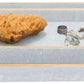 The Manchester Bath Collection by Pigeon & Poodle features three stacked rectangular trays with veneer trim, shown holding a natural sponge, ring, glass pebble, and cufflinks.