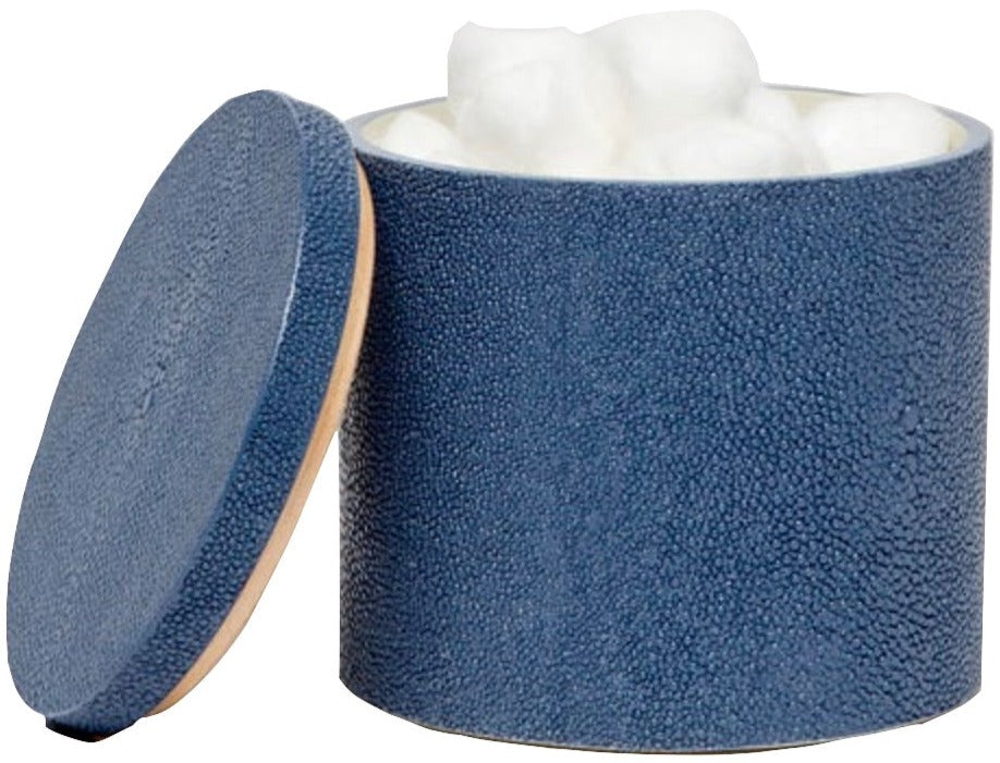 The Manchester Bath Collection by Pigeon & Poodle features a blue shagreen-textured cylindrical container with a detached lid, filled with white cotton balls.