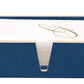 The Manchester Bath Collection by Pigeon & Poodle features a blue shagreen-textured napkin holder with white napkins accented by a gold cursive letter design.