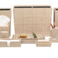 The Ghent Bath Collection by Pigeon & Poodle features beige woven grass accessories—tissue box, wastebasket, trays, containers, soap dispenser, and jars—arranged for a relaxed seaside-chic look on a white background.