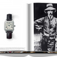 An open book reveals a wristwatch with a black band on the left page and a black-and-white photo of a man in a suit with a hat and mustache, dated 1904, on the right page. This timeless arrangement feels like something out of Assouline's The Impossible Collection of Watches (2nd Edition).