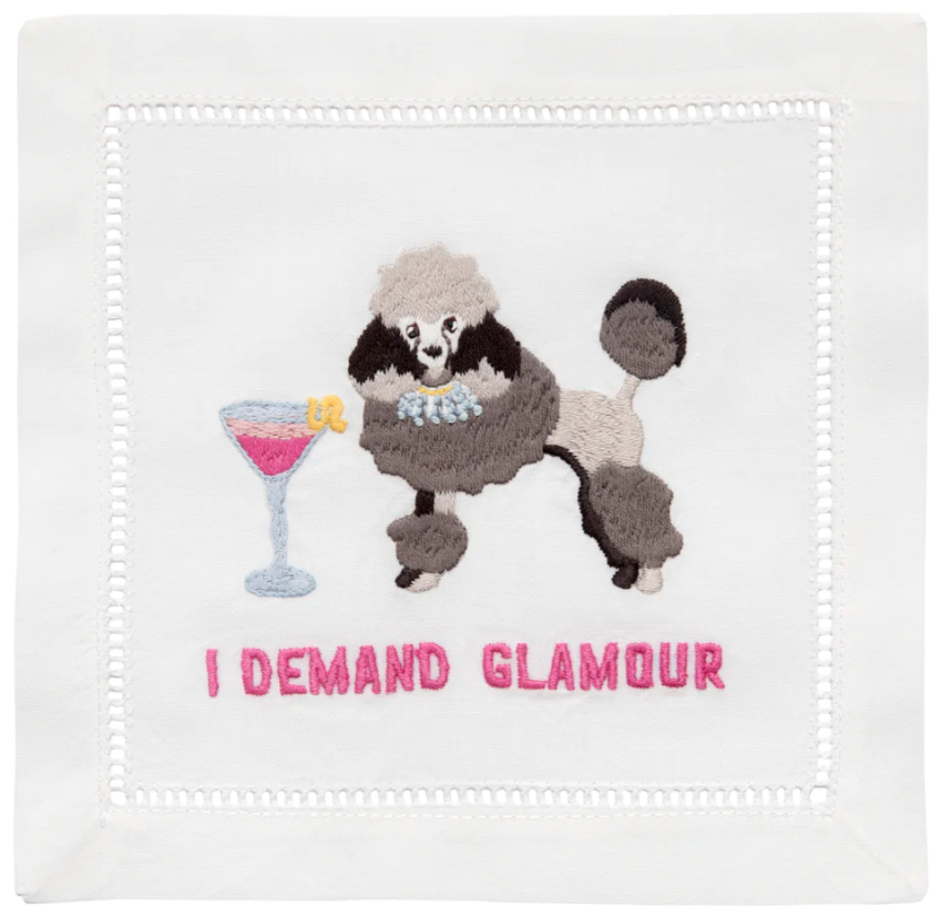 The August Morgan Cocktail Napkins "I Demand Glamour" feature an embroidered poodle next to a cocktail glass with a lemon twist, above the text on white cotton napkins with elegant hemstitching.