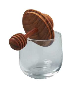 The Be Home Mini Teak and Glass Honey Jar features a handcrafted teak honey dipper with a round flat top resting on the rim of its clear glass jar.
