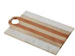 The Marble and Wood Board Collection by Be Home features a rectangular board with acacia wood and white marble stripes, ethically crafted and designed with a round hole in the top left corner.