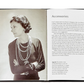 An open Little Book of Chanel displaying a black and white photograph of a woman from a past era, gazing thoughtfully to the side, with text on the opposite page discussing fashion accessories.