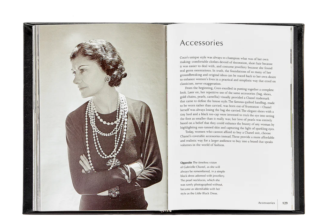 An open Little Book of Chanel displaying a black and white photograph of a woman from a past era, gazing thoughtfully to the side, with text on the opposite page discussing fashion accessories.