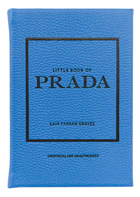 A blue book titled "Little Book of Prada" by Graphic Image, labeled as unofficial and unauthorized, details the history of the luxury fashion house.