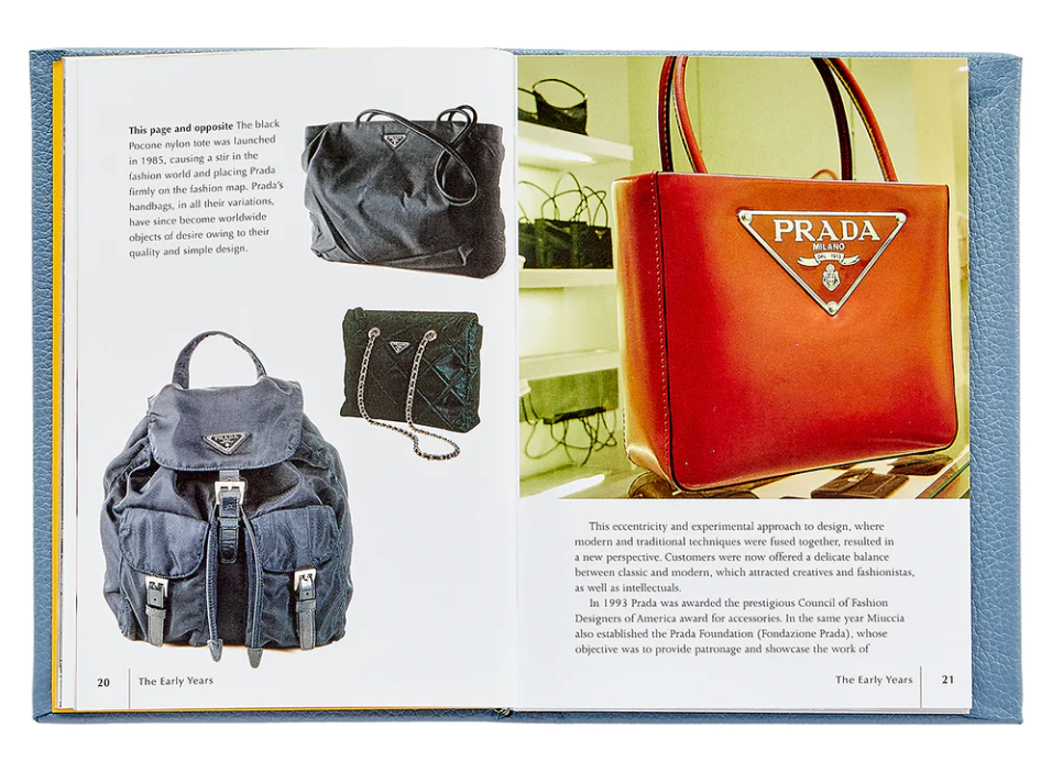 An open Little Book of Prada displaying various luxury Prada handbags from different years, showcasing the fashion house's evolution in design and fashion by Graphic Image.