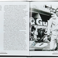 The open book, "The Story Of Porsche Black Leather" by Graphic Image, shows text about Steve McQueen's racing and the film "Le Mans" on the left page. On the right, there’s a black-and-white photo of a driver in racing gear beside a luxury Porsche race car.