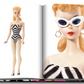 Open book displaying a page about the debut of the 1959 Barbie doll, an American phenomenon, featuring images of the Barbie doll in black and white swimwear published by Assouline.