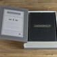 A Monopoly Vintage Bookshelf Edition by WS Game Company is open on a wooden surface, displaying the game’s box and a description of this classic Hasbro game on the inside cover.