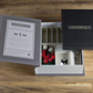 An open **Monopoly Vintage Bookshelf Edition** board game set by **WS Game Company** reveals a rule sheet, various Monopoly game pieces like houses, dice, tokens, and cards, all on a wooden surface. The lid rests partially open beside the box.