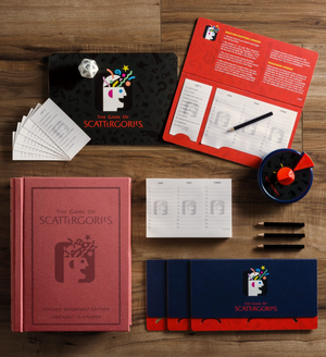 An overhead view of the Scattergories Vintage Bookshelf Edition game set by WS Game Company, featuring the game board, playing cards, pads, pencils, an iconic timer, a die, and the game box on a wooden surface.