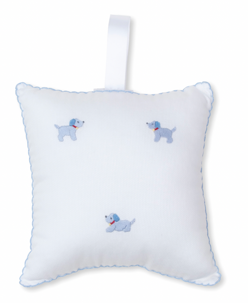 The Kissy Kissy Hand Embroidered Premier Puppies Musical Pillow with Tulle Bag in White/Light Blue is a charming square pillow adorned with a delicate blue border and small hand-embroidered blue dogs. It includes a white fabric loop on the top, making it easy for puppy friends to carry around.