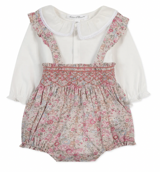 The Tartine et Chocolat Ensemble Court Liberty Pink Overall Top Set by Tartine et Chocolat features a baby romper with white long sleeves adorned with delicate lace trim, a floral smocked bodice decorated in pale pink, white, and beige floral patterns, ruffled straps, and an elasticized waist and leg openings.