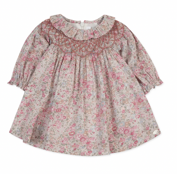 A Tartine et Chocolat Fabric Liberty Pink Dress, featuring a long-sleeve design with pink and beige floral patterns, a smocked neckline, and a ruffled collar, displayed on a white background.