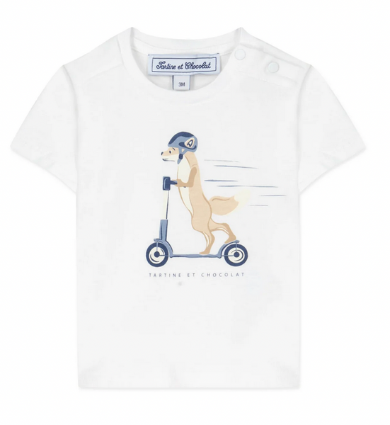 Introducing the Tartine et Chocolat Scooter Fox T-Shirt: A white baby boy tee adorned with a cute helmet-wearing fox riding a scooter, complete with the "Tartine et Chocolat" text underneath. Crafted from comfortable fabric, this delightful shirt is perfect for your little one's playful adventures.