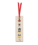 From Rifle Paper Co.'s Bookmark Collection, this cream-colored illustrated bookmark features four dogs in baskets, a red grosgrain ribbon, and the phrase "Sit. Stay. Read.