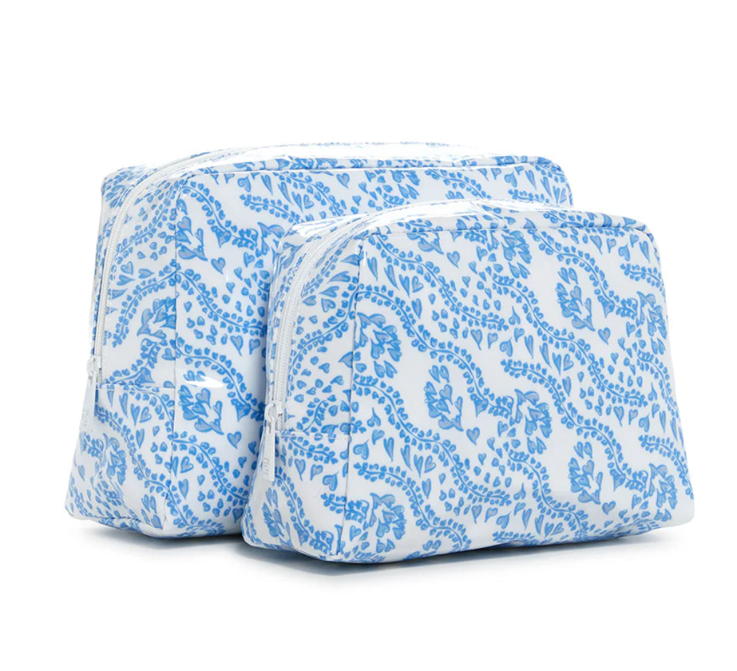 The Luxe Gloss All Heart Blue Travel Set by TRVL Design features two upright zippered pouches in blue floral and vine prints on white—one larger than the other—making a stylish, practical wash bag duo for travel.