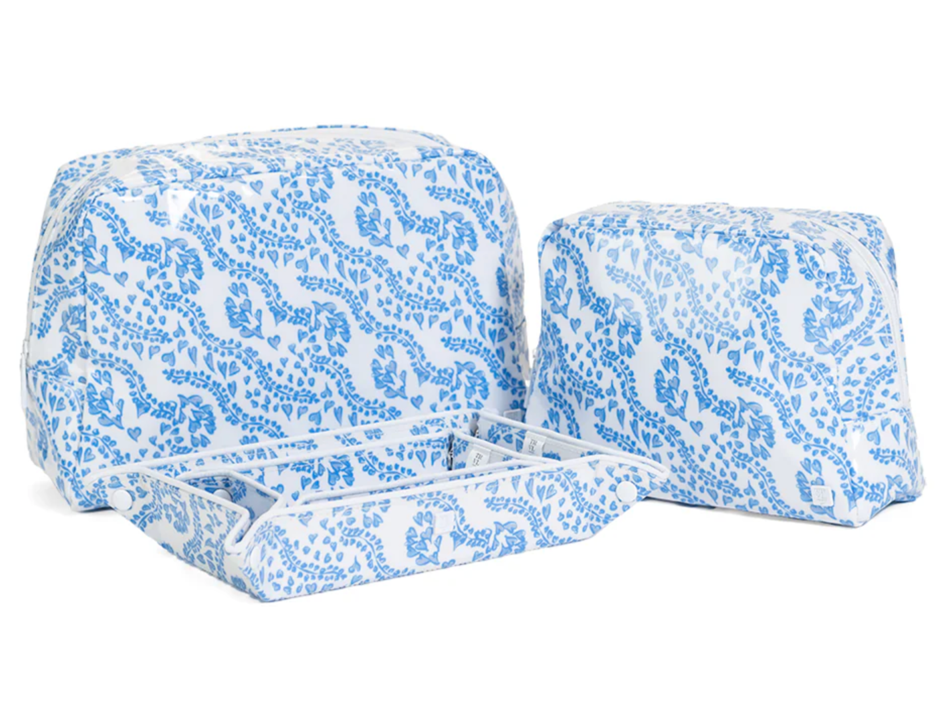 The Luxe Gloss All Heart Blue Travel Set by TRVL Design includes three blue and white floral pouches—one shown open with divided compartments—making it a stylish, organized wash bag trio for travel.