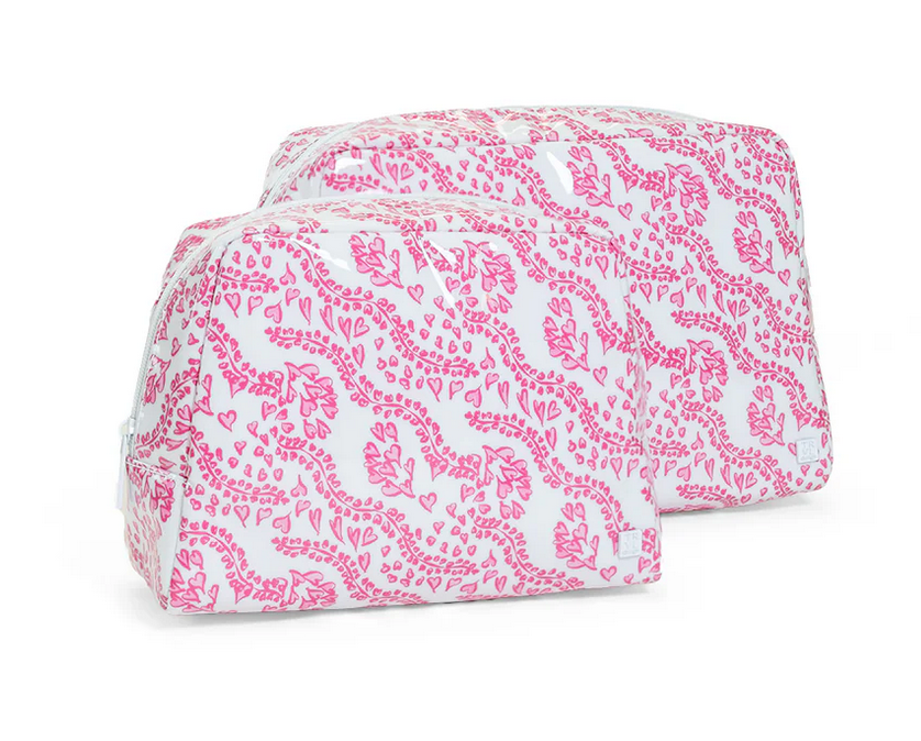 The TRVL Design Luxe Gloss All Heart Travel Set in Kelly Pink features two zippered rectangular pouches with pink heart and leaf patterns—ideal as cosmetic or wash bags for travel accessories.